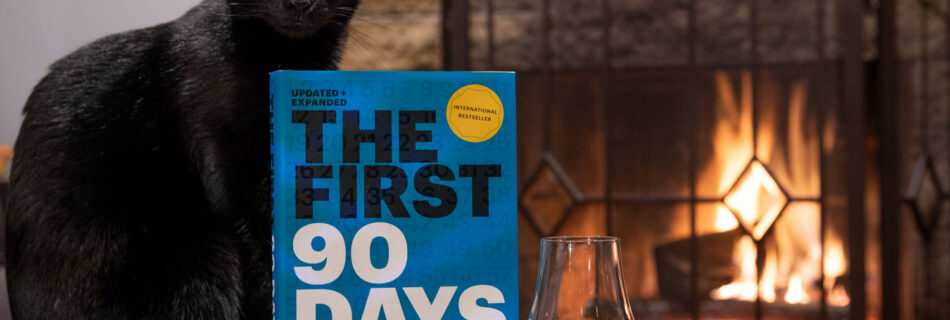 Book First 90 Days on a Table by a fire with a whiskey and a cat